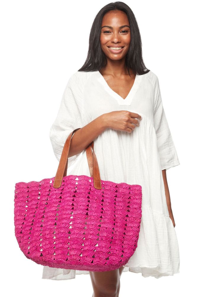 a woman is holding a pink handbag