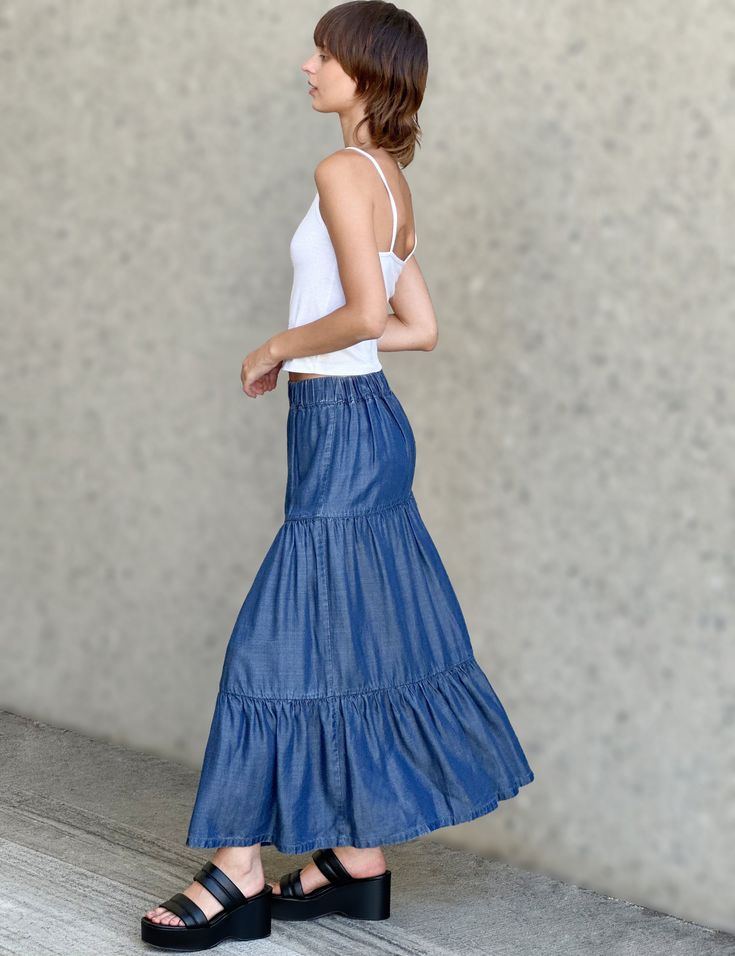 Ultra-light, ultra-soft, ultra-flowy, and ultra cute! The Flounce Denim Maxi Skirt from Billy T, with layered, pleated construction in a fun-and-flattering cut. The cover model is 5'7" wearing size small Fabric: 100% Tencel Length: 35" from waistband to longest point Casual Flowy Tiered Skirt, Flowy Tiered Casual Skirt, Denim Skirt With Elastic Waistband, Relaxed Fit, Relaxed Denim Skirt With Elastic Waistband, Relaxed Fit Denim Skirt With Elastic Waistband, Spring Medium Wash Skirt With Elastic Waistband, Spring Denim Skirt With Elastic Waistband, Relaxed Tiered Skirt For Spring, Long Denim Blue Skirt For Summer