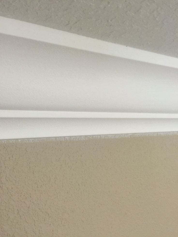 the corner of a room with a light fixture on it's side and a white wall in the background