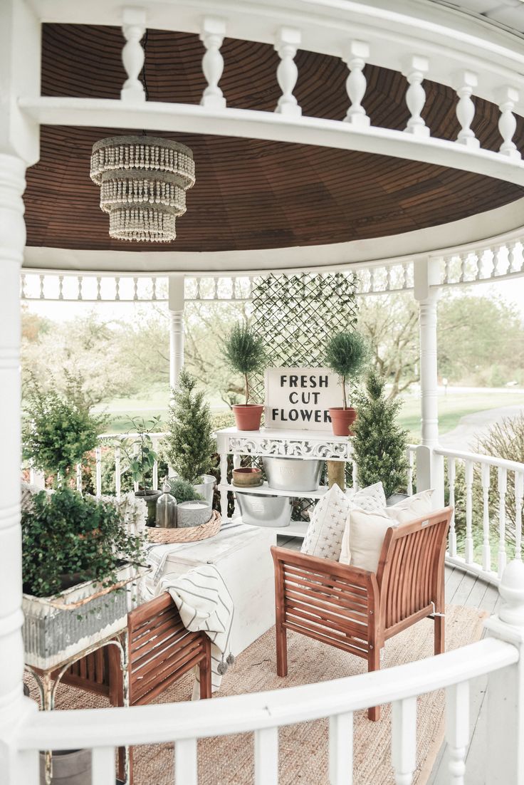 a porch covered in plants and potted plants