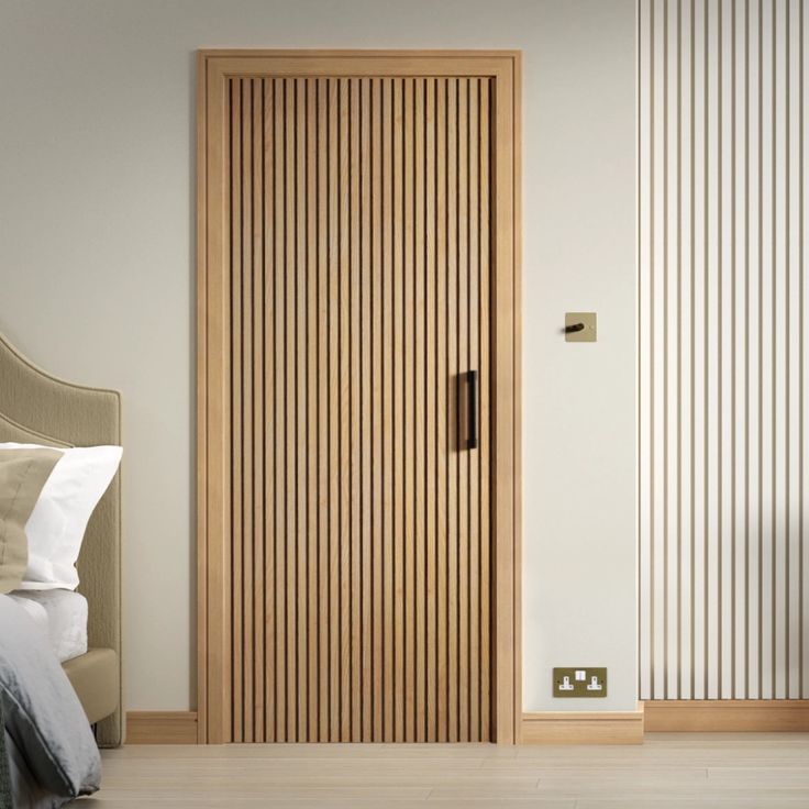 a bed sitting next to a wooden door in a bedroom