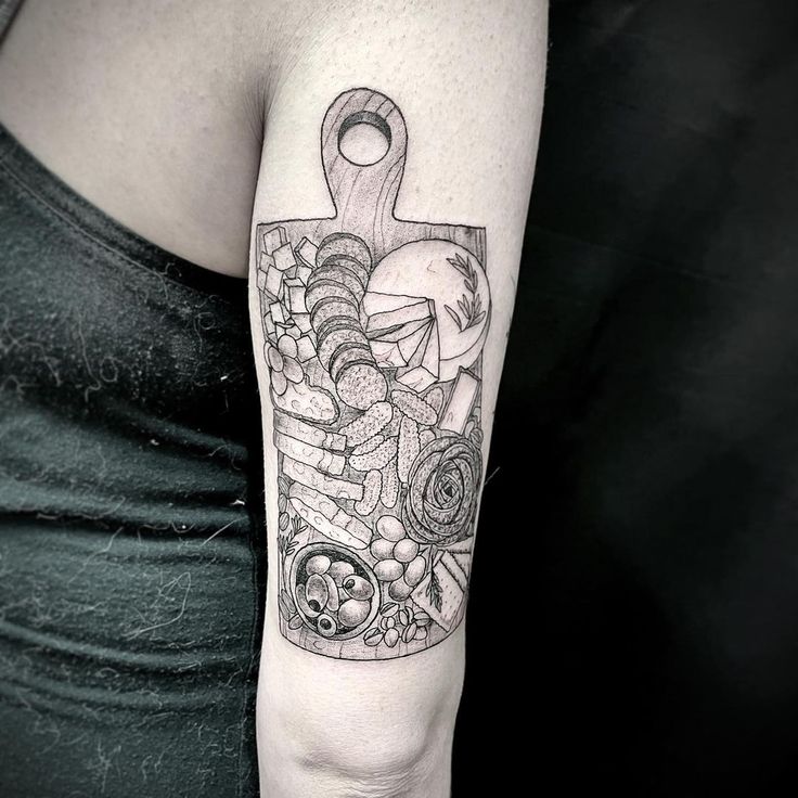 a woman with a tattoo on her arm holding a knife and some food in it