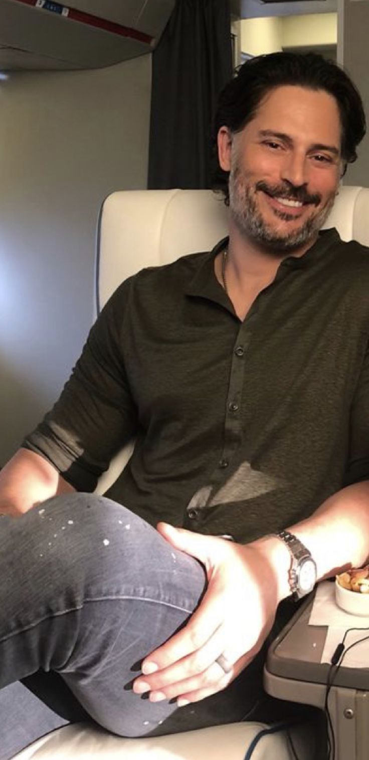 a man sitting in an airplane with his feet up on the table next to him