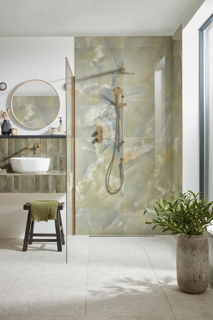 a bathroom with a sink, mirror and shower head in the corner next to a stool