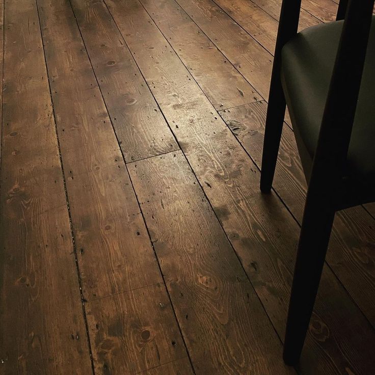 an empty room with wooden floors and chairs