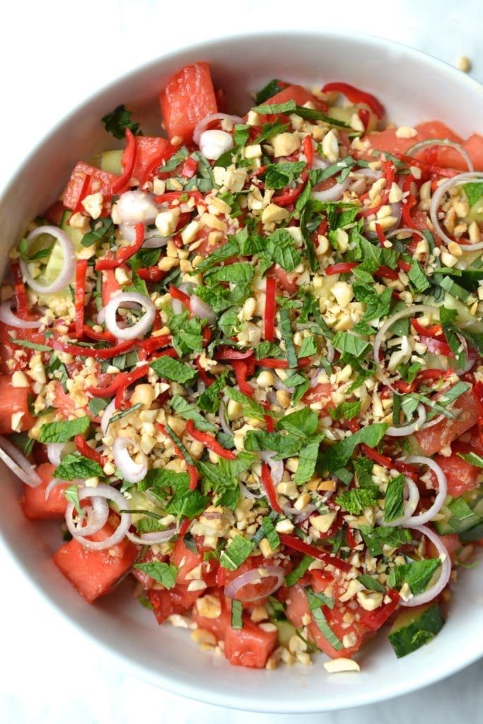 a white bowl filled with lots of veggies and seasoning on top of it