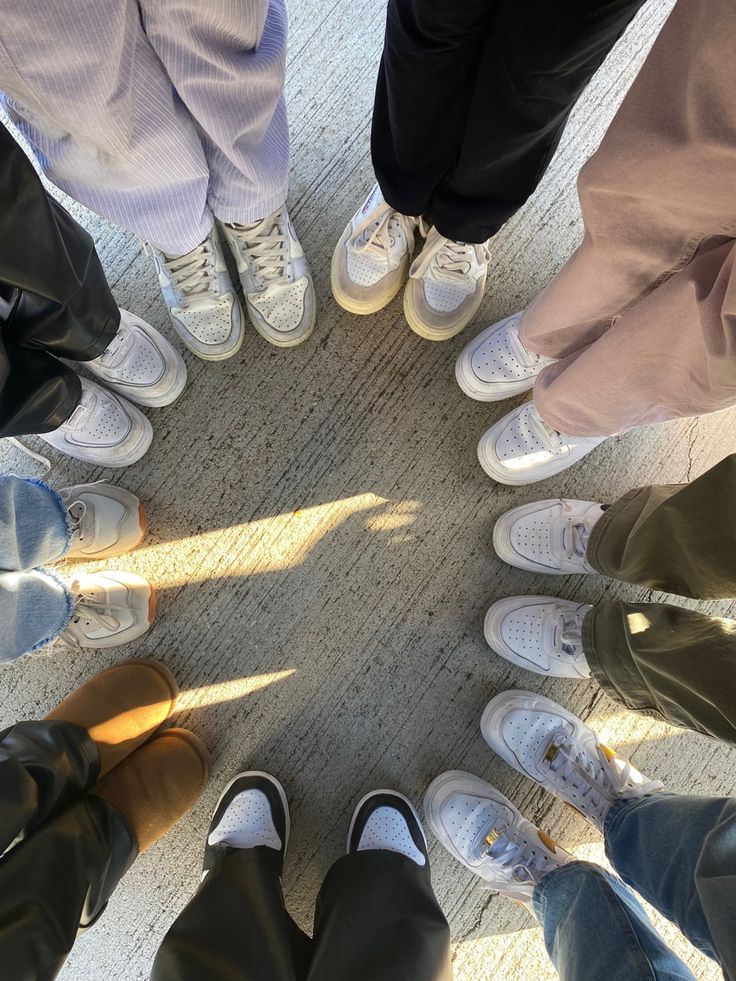 a group of people standing in a circle with their feet on each other's legs