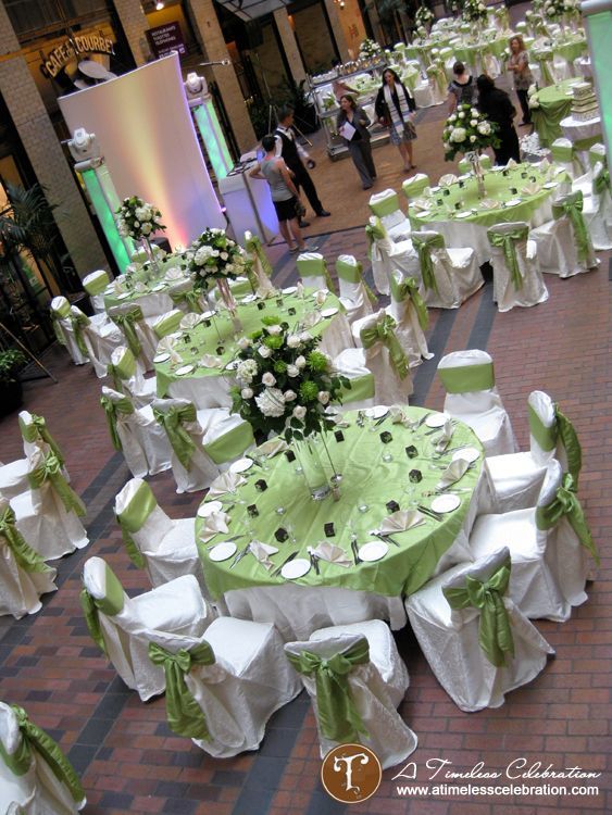 tables and chairs covered in white and green linens