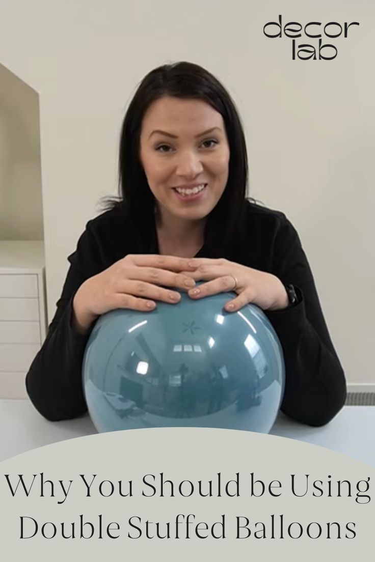 a woman sitting at a table with a blue ball in front of her and the words, why you should be using double stuffed balloons