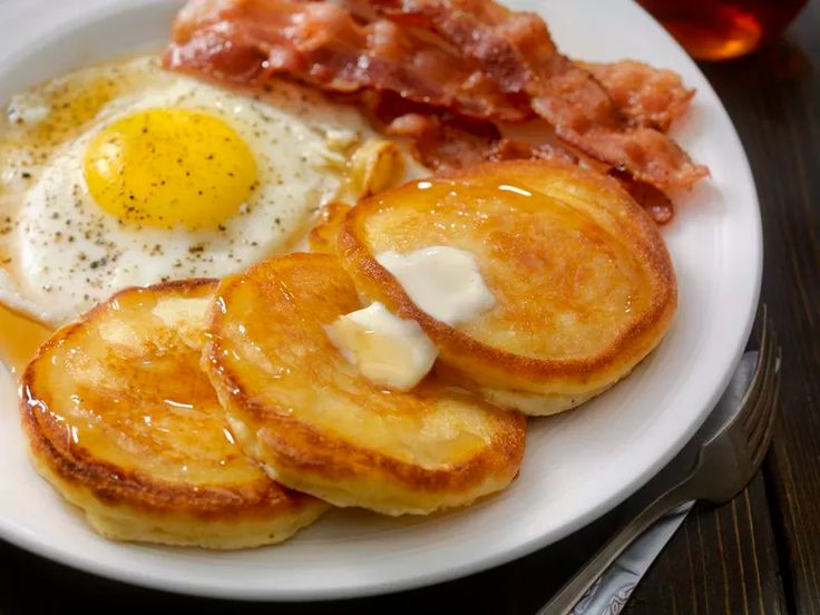 a plate with pancakes, eggs and bacon on it