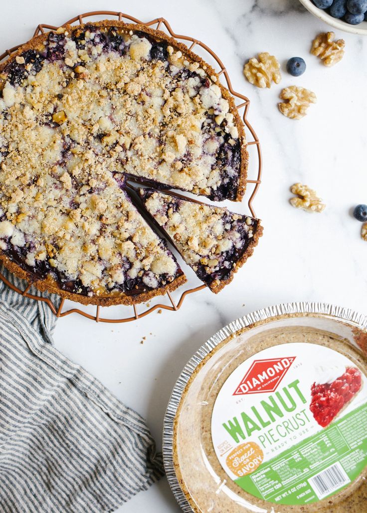 a blueberry crumble pie next to a container of yogurt