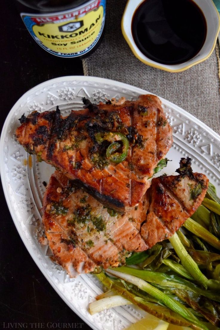 grilled salmon and asparagus on a white plate next to a cup of coffee