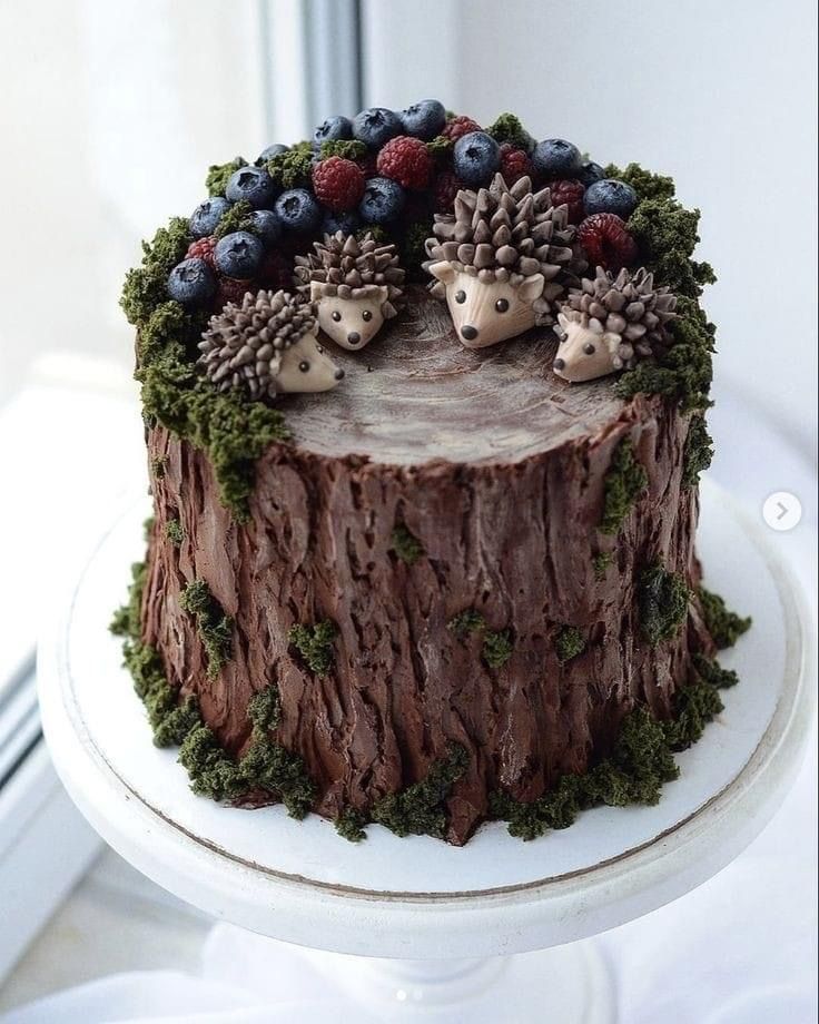 there is a cake decorated with hedges and berries on top of a tree stump