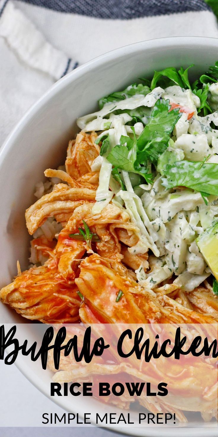 a white bowl filled with pasta, chicken and salad next to a lemon wedge on the side