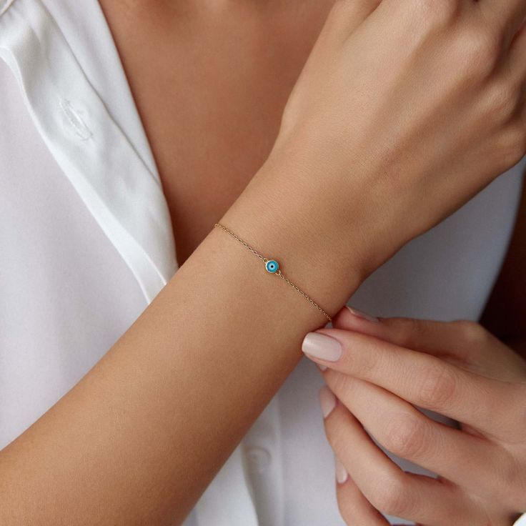 Elevate your style with our One Evil Eye Bracelet, crafted from 14k solid gold. This minimal piece features a double-sided ocean blue evil eye, offering protection and elegance from every angle. Perfect for a delicate, everyday look. This bracelet is crafted with real 14k solid gold (not plated, not vermeil, not gold filled) The eye is created by applying enamel on top of solid gold.  In our enamel application process, the enamel is bonded with gold under extreme temperatures to ensure your piec Elegant Turquoise Birthstone Bracelets, Everyday Turquoise 14k Gold Jewelry, Everyday 14k Gold Turquoise Jewelry, Blue Dainty Birthstone Bracelets, Minimalist Blue Evil Eye Jewelry, Blue Minimalist Evil Eye Jewelry, Everyday Blue Tarnish-resistant Jewelry, Blue 14k Gold Everyday Bracelets, Blue Everyday Bracelet Jewelry