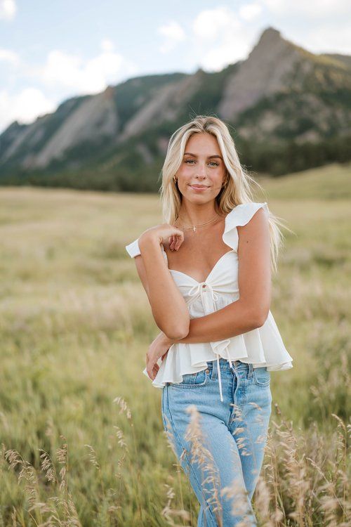 a beautiful blonde woman standing in tall grass