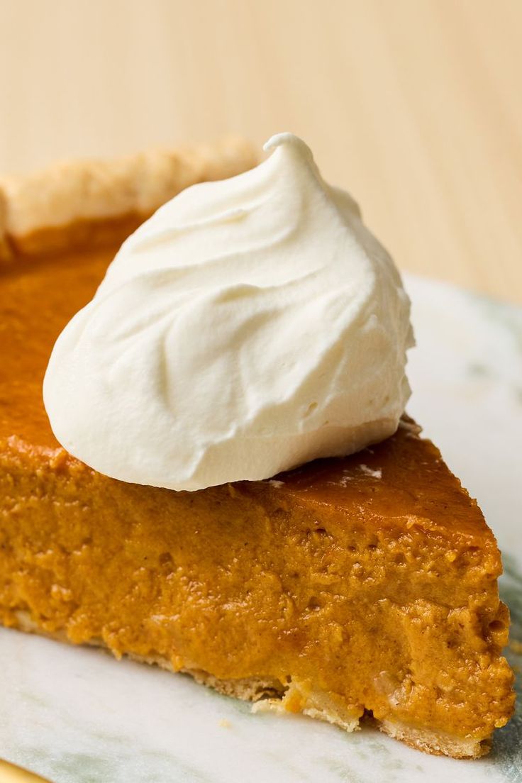 a slice of pumpkin pie with whipped cream on top