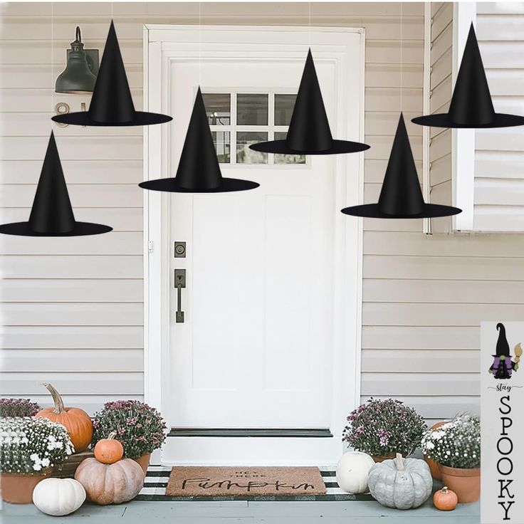 a front porch decorated for halloween with black witches hats