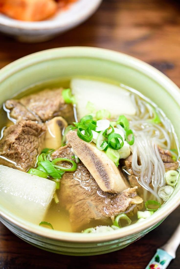 a bowl of beef and vegetable soup on a table