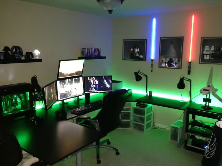 a room with multiple computer monitors and lights on the wall, all lit up in different colors