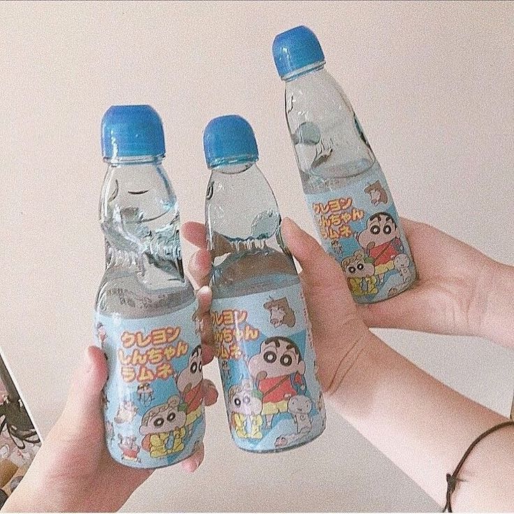 three water bottles in the shape of animals are being held by someone's hand