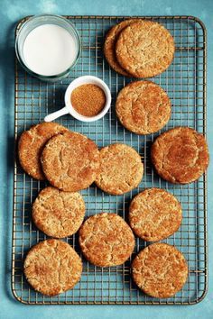 cookies cooling on a wire rack next to a cup of milk and a bowl of sugar