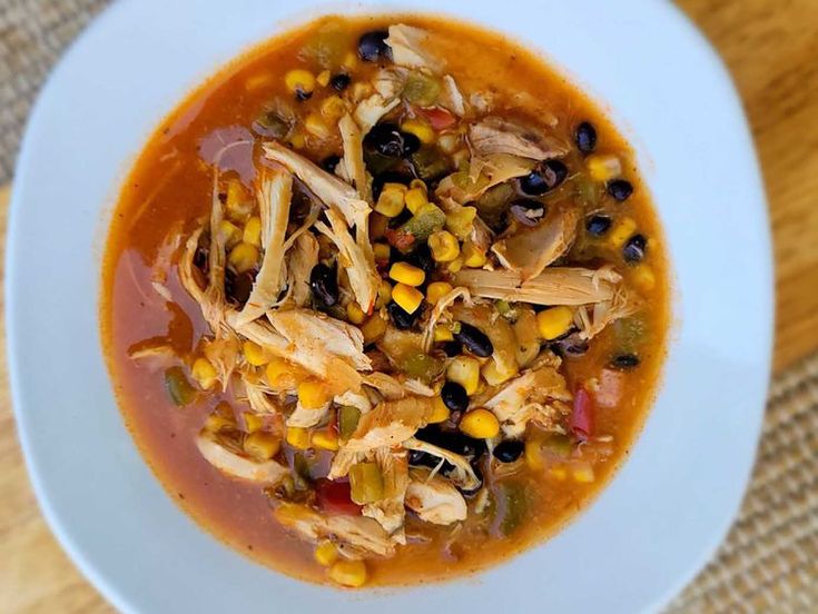 a bowl of chicken tortilla soup with corn and black beans