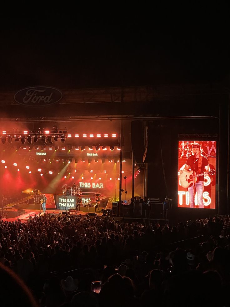 the stage is lit up with red lights and people are sitting in front of it