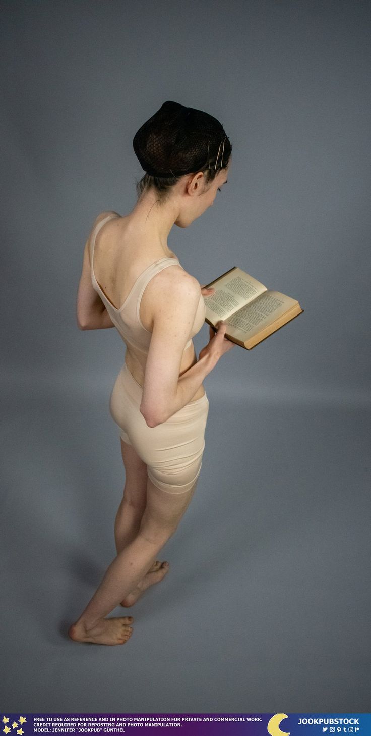 a woman is reading a book and posing for the camera with her hands on her hips