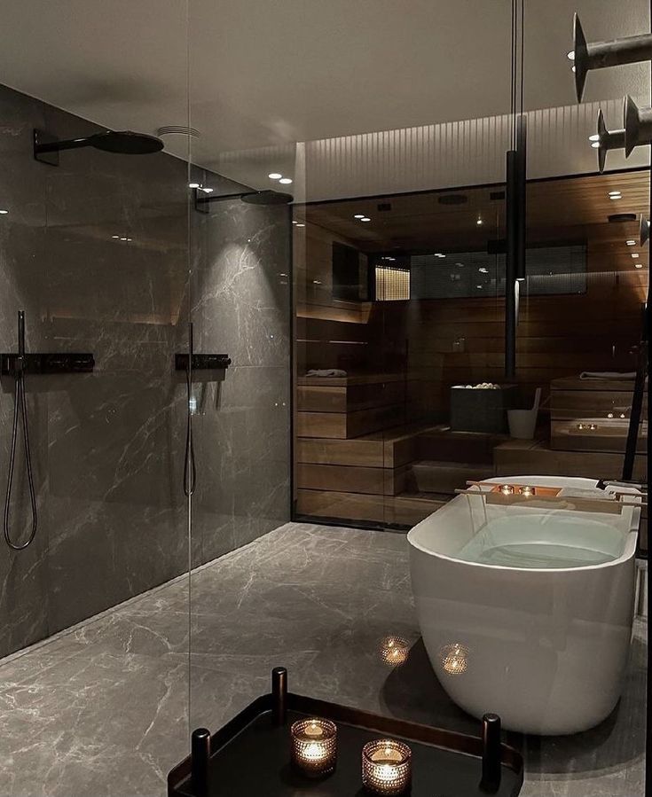 a bathroom with a large bathtub next to a walk in shower and glass walls