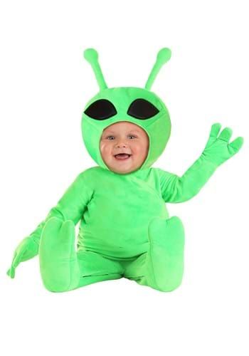 a baby in a green alien costume sitting on the ground with its arms out and eyes closed