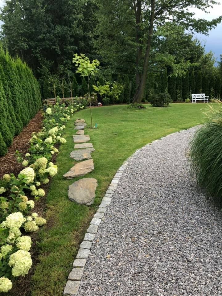 a stone path in the middle of a garden