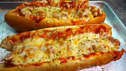 two cheesy pizzas sitting on top of a baking pan next to each other