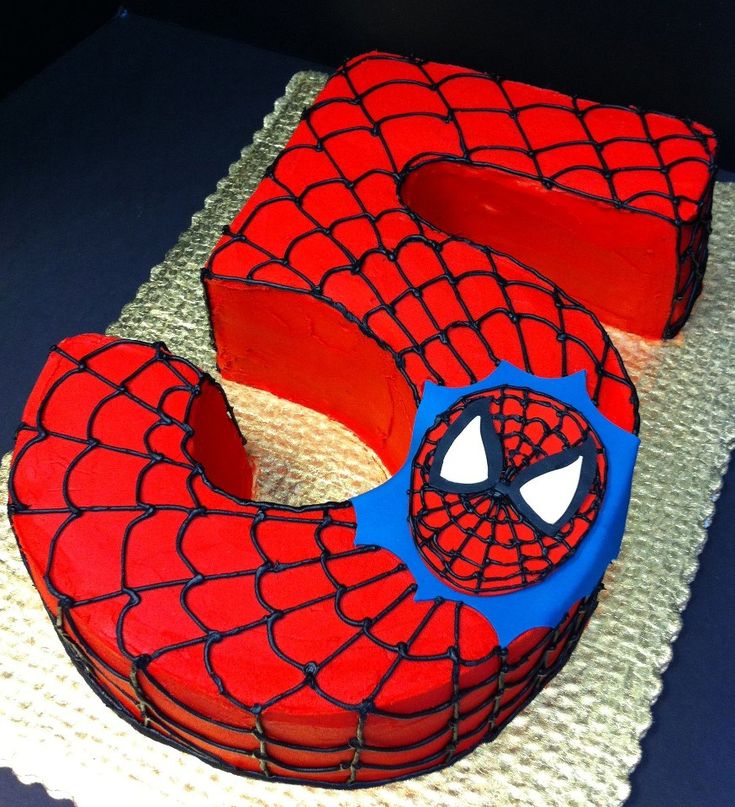 a spiderman themed cake is sitting on a table