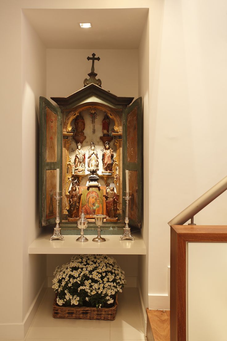 an altar with flowers in front of it and a cross on the wall behind it