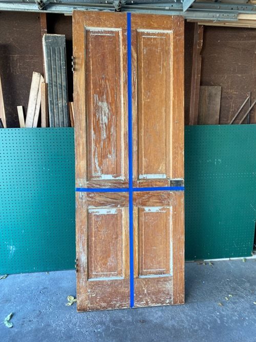 an old wooden door with blue tape on the bottom and sides in front of it