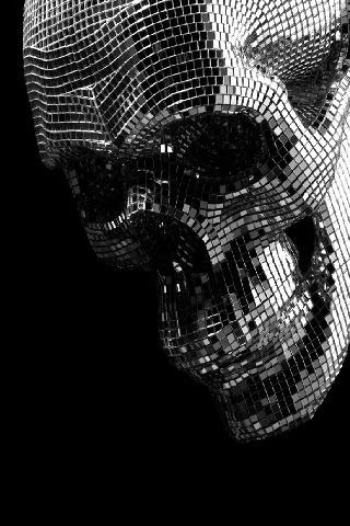 a black and white photo of a skull made out of disco ball mosaics on a black background