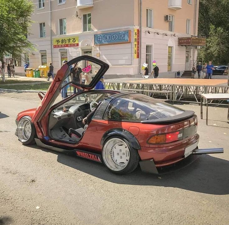 an orange car with its door open on the street