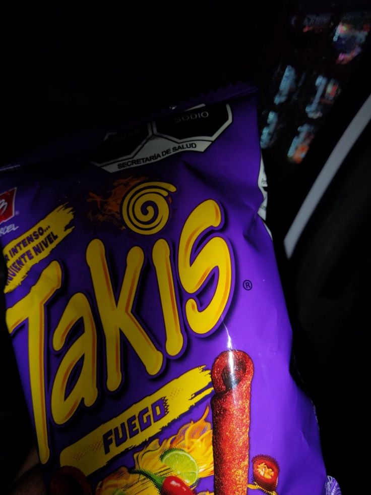 a bag of taks filled with fruit sitting on top of a car seat in the dark