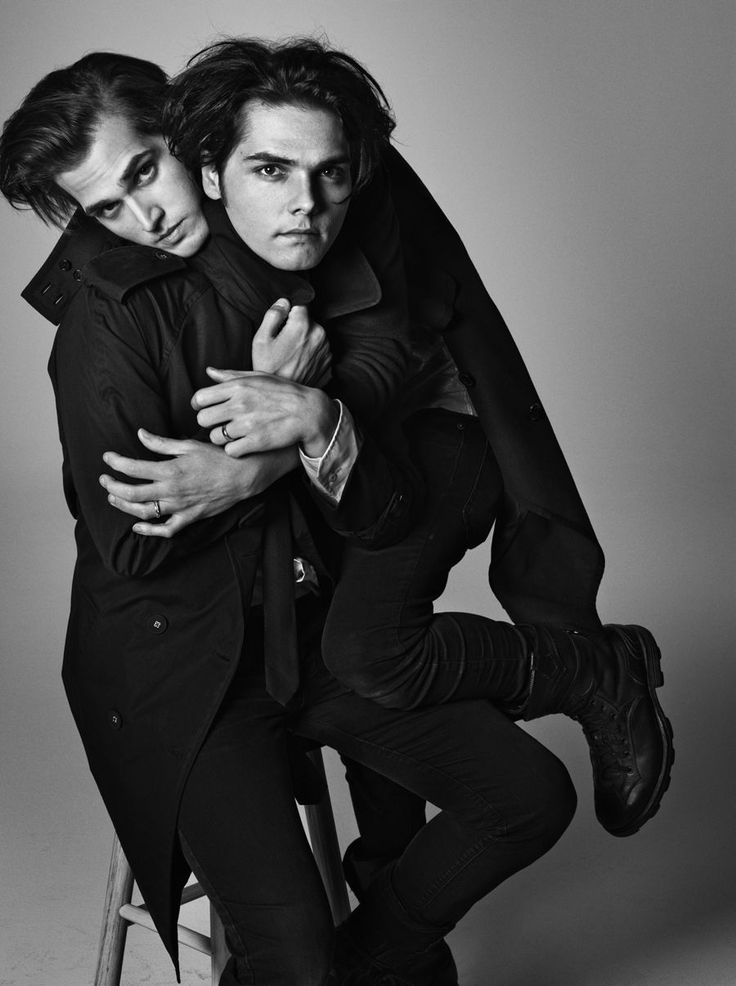 two men are hugging each other while sitting on a chair with their arms around one another