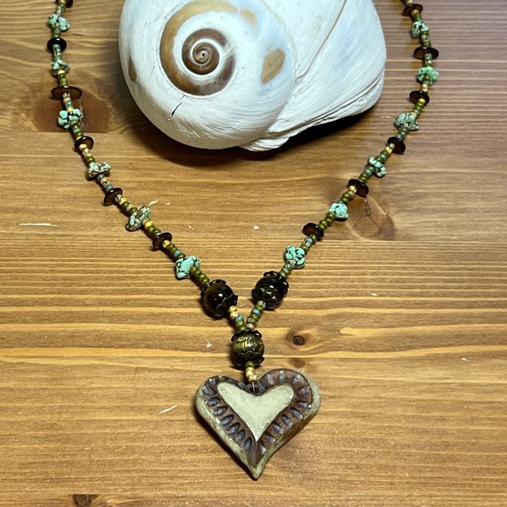 Handmade Clay Heart Pendant Necklace Tiger Eye Round Beads, Stone Chips, Green, Tan, Browns Approximately 21” 11 On Back Of Heart Bohemian Beaded Heart Pendant Necklace For Gift, Bohemian Beaded Necklace With Heart Pendant As Gift, Green Heart-shaped Beaded Necklace Gift, Bohemian Beaded Necklace With Heart Pendant, Bohemian Beaded Necklace With Heart Beads, Adjustable Heart Beaded Necklaces, Handmade Beaded Heart Pendant Necklace, Handmade Adjustable Beaded Necklace With Heart Pendant, Bohemian Handmade Heart Pendant Beaded Necklace