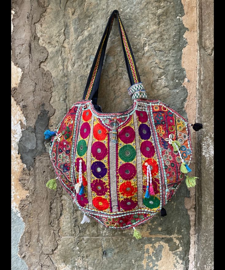 About bag  Indo-gypsy fusion, everyday use hand bag made from Banjara fabrics sourced from Vintage tribal costumes of regions of Rajastan and Gujarat. These are embellished with light catching coins, and intricate bead work tassels. Size - length 15 inches/ width 21 inches Company details:  Company name: Houseoftextile  Contact number: +919784447473  Email id: houseoftextile77@gmail.com  Shipping & custom : Delivery through one of the finest service providers : Skyway, Fedex, UPS  And DHL. Any l Bohemian Multicolor Potli Bag For Festive Occasions, Bohemian Multicolor Potli Bag For Festive Season, Multicolor Bohemian Potli Bag For Festive Occasions, Festive Embroidered Tote Bag, Festive Multicolor Tote Bag, Traditional Multicolor Embroidered Hobo Bag For Travel, Bohemian Potli Bag With Mirror Work For Festive Occasions, Navratri Bohemian Potli Bag With Handwork, Multicolor Festive Shoulder Bag For Festival