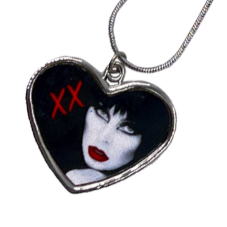 Bootique Valentines Exclusive! Elvira Red Lips Heart Necklace featuring Elvira Mistress Of The Dark in cloassic noir style printed on a heart pendant, heart measuring 1.2 in (3cm) with a zinc alloy chain, chain length 18 in(46cm) with extender to 20in (51cm). Hand printed in the USA. Gothic Heart Necklace With Heart Pendant, Gothic Heart Necklace With Heart Charm, Gothic Heart-shaped Necklace For Valentine's Day, Gothic Heart Shaped Necklace For Gifts, Gothic Metal Heart Necklace For Valentine's Day, Gothic Heart Necklace As Gift, Gothic Heart Shaped Necklace As Gift, Gothic Heart Charm Necklace For Gift, Gothic Heart-shaped Necklace For Gift