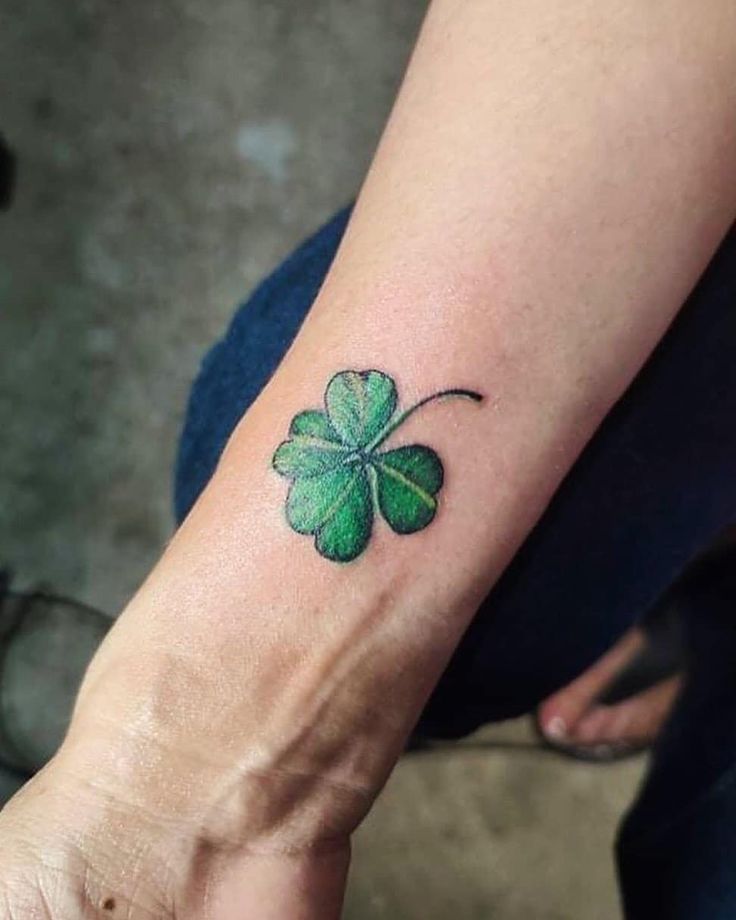 a small shamrock tattoo on the wrist