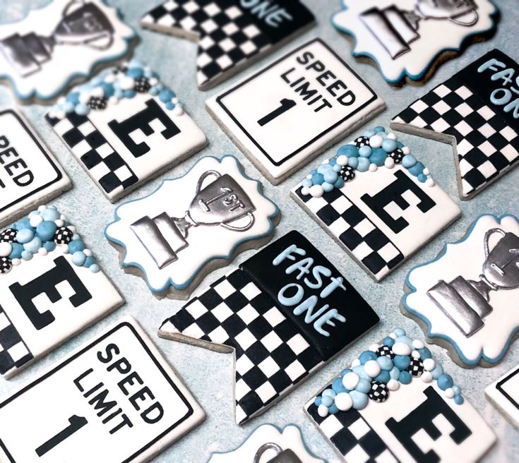 decorated cookies are arranged on a table with black and white checkerboard designs,