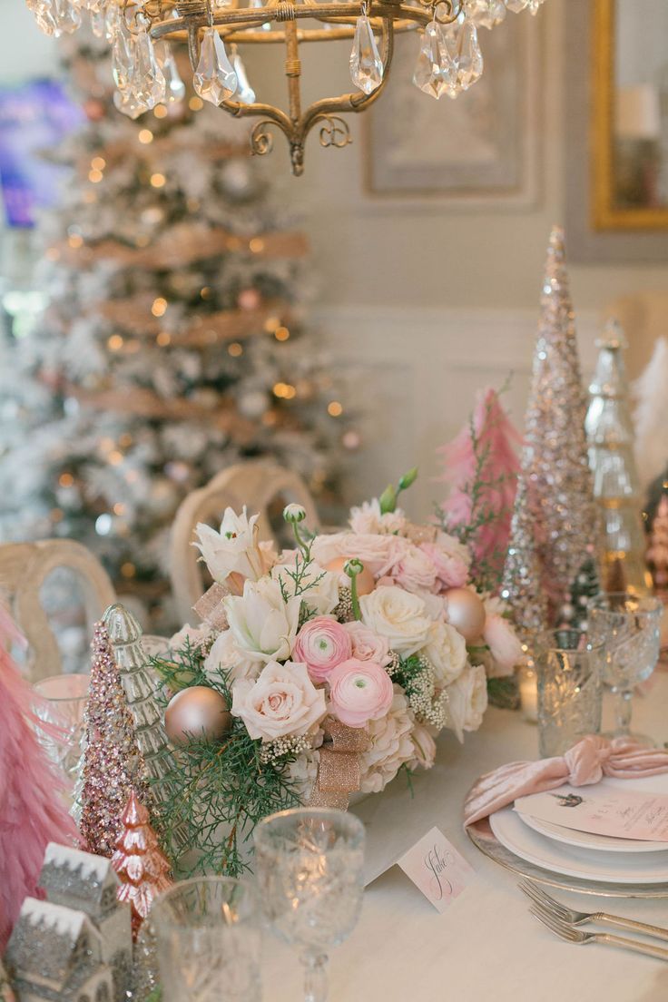 a dining room table decorated for christmas with pink and white flowers