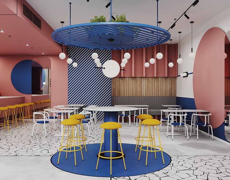 the interior of a colorful restaurant with yellow stools and round tables in front of pink walls