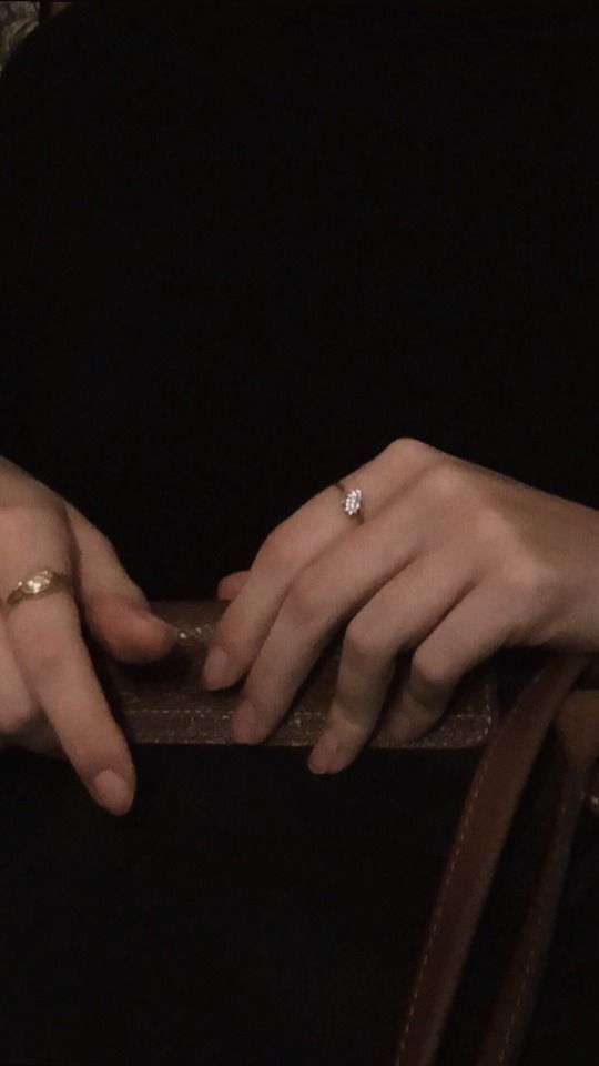 two hands holding onto each other with gold rings