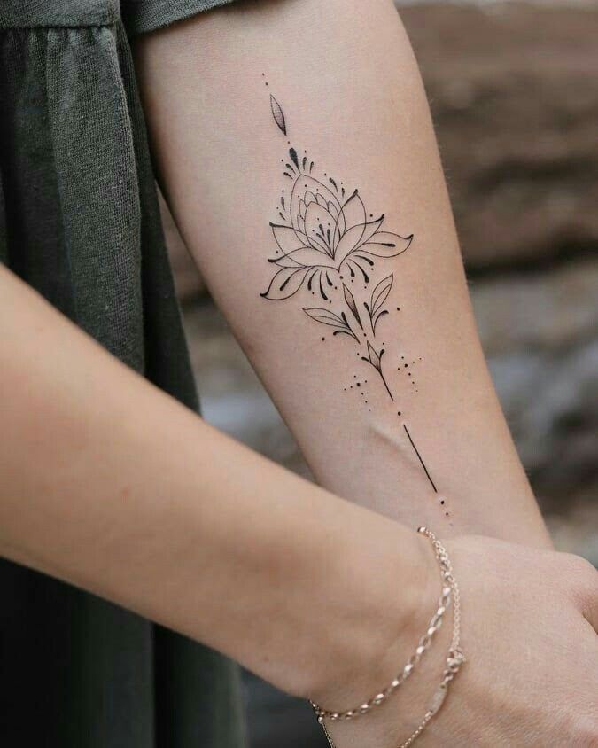 a woman's arm with a flower tattoo on the left side of her arm