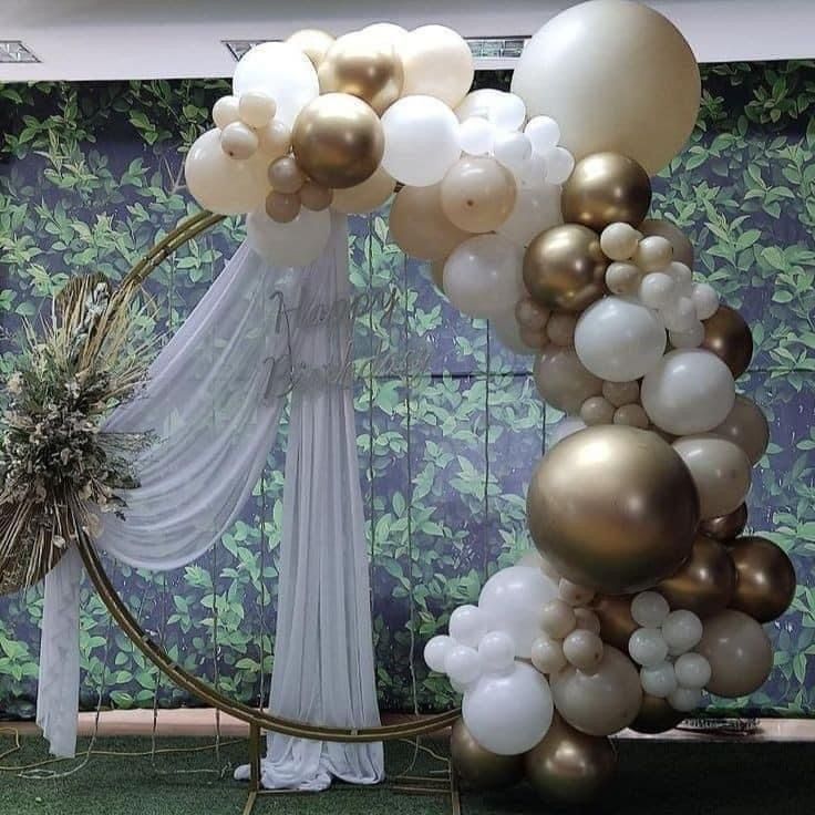 a balloon arch with white and gold balloons